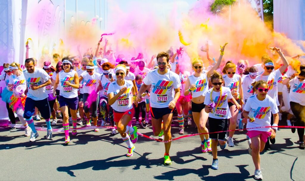 People run a marathon holding colored smoke in their hands